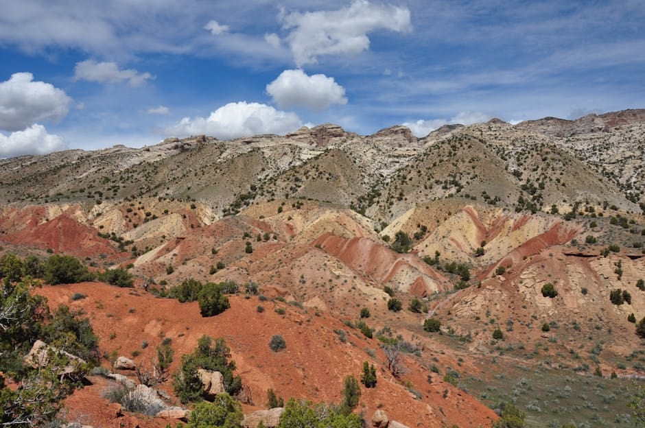 Stunning view of layered rock formations and vegetation in Vernal, Utah under a clear blue sky.